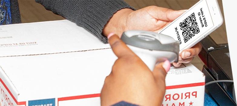 Customer presenting a USPS Label Broker QR code to print a label and ship a package at the Post Office counter.